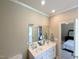 Well-lit bathroom featuring a double sink vanity, mirror, and doorway leading to a bedroom at 70 Dexterfield Dr, Fuquay Varina, NC 27526