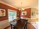 Charming dining room featuring a dark wood table, wainscoting, and natural light at 70 Dexterfield Dr, Fuquay Varina, NC 27526