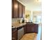 Charming kitchen offering dark wood cabinets, stainless steel dishwasher, and tile floors at 70 Dexterfield Dr, Fuquay Varina, NC 27526