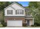 Charming two-story home with a brick and siding exterior, complemented by a well-maintained lawn and mature trees at 702 Calavaras Ln, Knightdale, NC 27545
