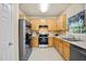 Well-lit kitchen featuring wooden cabinets, stainless steel appliances, and a window at 702 Calavaras Ln, Knightdale, NC 27545