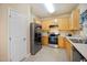 Well-lit kitchen featuring wooden cabinets, stainless steel appliances, and a door at 702 Calavaras Ln, Knightdale, NC 27545