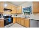 Kitchen featuring wooden cabinets, stainless steel appliances, sink and window at 702 Calavaras Ln, Knightdale, NC 27545