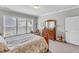 Bedroom with bright, natural light and featuring a decorative wooden dresser, chair and plush carpet at 704 Haven Peak Ln, Wake Forest, NC 27587