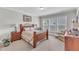 Bedroom featuring a wooden bed frame, plush carpet, natural light, and decorative lamps and chair at 704 Haven Peak Ln, Wake Forest, NC 27587