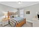 Bedroom with natural lighting, neutral colors and featuring a wooden bed frame, lamp and dresser at 704 Haven Peak Ln, Wake Forest, NC 27587