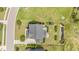 Aerial view of a house with a lush lawn, mature trees, stone patio with a firepit and other landscaping at 710 Legacy Falls S Dr, Chapel Hill, NC 27517