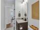 Well-lit bathroom featuring a stylish vanity with stone countertop, modern fixtures, and decorative wall art at 717 Utley St, Holly Springs, NC 27540