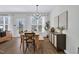 Bright dining room with a chandelier, wood table, and a modern sideboard with decorative art at 717 Utley St, Holly Springs, NC 27540