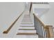 Staircase with wood and white risers, black metal railings, and wood banisters at 717 Utley St, Holly Springs, NC 27540