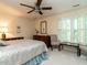 Sunlit bedroom showcasing a large window, ceiling fan, and classic furnishings at 7312 Sweet Bay Ln, Raleigh, NC 27615