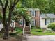 Two-story brick home with well-manicured front yard and lush trees, offering curb appeal at 7312 Sweet Bay Ln, Raleigh, NC 27615