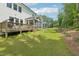 Expansive backyard featuring a wood deck, screened-in porch, green lawn, and wooded area with a swing set at 772 Mirkwood Ave, Apex, NC 27523