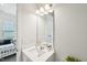 Well-lit bathroom with a white vanity, mirror, and tiled shower at 772 Mirkwood Ave, Apex, NC 27523