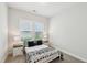 Cozy bedroom with a black and white comforter, side tables, and natural light at 772 Mirkwood Ave, Apex, NC 27523