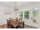 Bright dining room features a wooden table, chandelier, and views of the backyard at 772 Mirkwood Ave, Apex, NC 27523