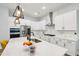 Modern kitchen features white cabinetry, stainless appliances, an island, and designer lighting at 772 Mirkwood Ave, Apex, NC 27523