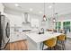 A modern kitchen is open to the breakfast nook and has stainless steel appliances and white cabinets at 772 Mirkwood Ave, Apex, NC 27523