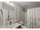 Neutral bathroom with a cherry vanity, matching mirror and shower/tub combo at 7873 Cape Charles Dr, Raleigh, NC 27617
