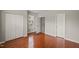 Spacious bedroom featuring hardwood floors, a window with blinds, and closet storage space at 7873 Cape Charles Dr, Raleigh, NC 27617