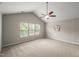 Bright, carpeted bedroom with three windows and a vaulted ceiling featuring a ceiling fan and simple decor at 7873 Cape Charles Dr, Raleigh, NC 27617