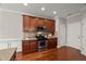 Kitchen area featuring stainless steel appliances, tile backsplash, and warm wood cabinets at 7873 Cape Charles Dr, Raleigh, NC 27617