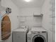 This laundry room features a washer, a dryer, an ironing board, and ample shelving for convenient storage at 7873 Cape Charles Dr, Raleigh, NC 27617