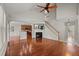 Bright living room featuring hardwood floors, fireplace, staircase, and views of the kitchen and entryway at 7873 Cape Charles Dr, Raleigh, NC 27617
