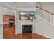 Living room featuring hardwood floors, fireplace, staircase and an open concept to the kitchen at 7873 Cape Charles Dr, Raleigh, NC 27617