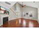 Bright living room featuring hardwood floors, fireplace, staircase, ceiling fan, and an open-concept layout at 7873 Cape Charles Dr, Raleigh, NC 27617