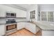Modern kitchen with white cabinets, stainless steel appliances, and granite countertops at 804 Town Side Dr, Apex, NC 27502