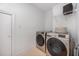 Bright laundry room features modern front-load washer and dryer and useful wire shelving for storage at 804 Town Side Dr, Apex, NC 27502