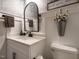 This lovely bathroom features a decorative mirror over a vanity with black hardware and a toilet at 83 Sawyer Ct, Wendell, NC 27591