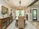 Elegant dining room showcasing a decorative rug, wooden table, and views of the landscaped yard at 83 Sawyer Ct, Wendell, NC 27591
