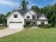Charming two-story home featuring a landscaped yard, black shutters, and a two-car garage at 83 Sawyer Ct, Wendell, NC 27591