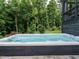 Relaxing hot tub with a view of the lush green backyard and surrounding trees at 83 Sawyer Ct, Wendell, NC 27591