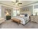 Spacious bedroom boasts trey ceiling, large windows and upholstered bed with stylish accent furniture at 83 Sawyer Ct, Wendell, NC 27591
