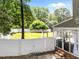 Fenced-in backyard with a deck including outdoor furniture, porch swing and hammock at 8808 Colesbury Dr, Raleigh, NC 27615