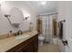 Bathroom featuring a dark wood vanity, granite countertop, bronze fixtures, and shower with curtain at 8808 Colesbury Dr, Raleigh, NC 27615
