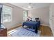 Cozy bedroom features a blue accent rug, natural light from windows and a ceiling fan at 8808 Colesbury Dr, Raleigh, NC 27615