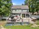 Back of the home with a deck including a dining table, grill, fire pit, and porch swing at 8808 Colesbury Dr, Raleigh, NC 27615