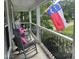 Inviting front porch features rocking chairs, pink pillows, and flag at 8808 Colesbury Dr, Raleigh, NC 27615