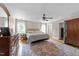 Main bedroom featuring a ceiling fan, wood floors, a large area rug, and natural light at 8808 Colesbury Dr, Raleigh, NC 27615