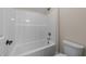 Clean bathroom with a white tub and shower combination, complemented by gold fixtures and neutral walls at 90 Lane Farms Way Way, Holly Springs, NC 27540