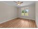 An empty bedroom with wood flooring, ceiling fan, and a view from a window at 90 Lane Farms Way Way, Holly Springs, NC 27540