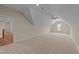 Expansive bonus room featuring plush carpet, ample natural light, and a modern ceiling fan at 90 Lane Farms Way Way, Holly Springs, NC 27540