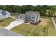 Aerial view of a gray two-story home with large yard and three car garage at 90 Lane Farms Way Way, Holly Springs, NC 27540