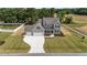 Stunning aerial view of a two-story home with a three-car garage, lush lawn, and modern landscaping at 90 Lane Farms Way Way, Holly Springs, NC 27540