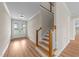 Bright foyer featuring a staircase with wood treads, white risers and walls, and glass panel double doors at 90 Lane Farms Way Way, Holly Springs, NC 27540