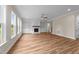 Open-concept living room featuring a cozy fireplace with built-ins, hardwood flooring, and large windows at 90 Lane Farms Way Way, Holly Springs, NC 27540